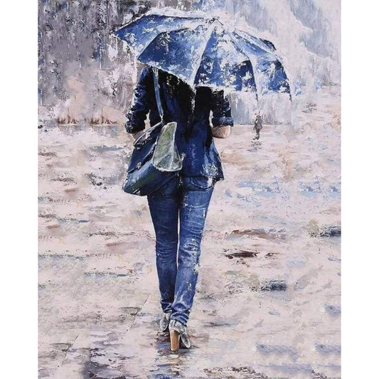 Woman dressed in blue under an umbrella